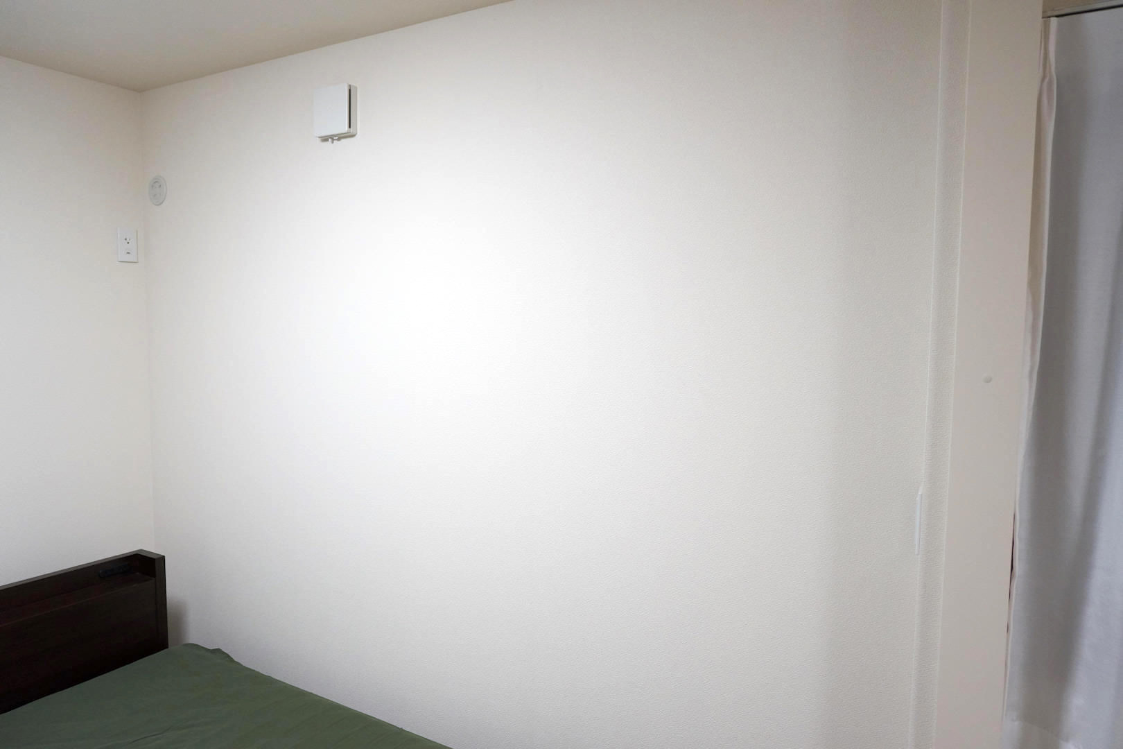 筆者の寝室の一部。白い壁の部屋を借りたのは良いのですが、この壁に直接飾るのはマズイですね。