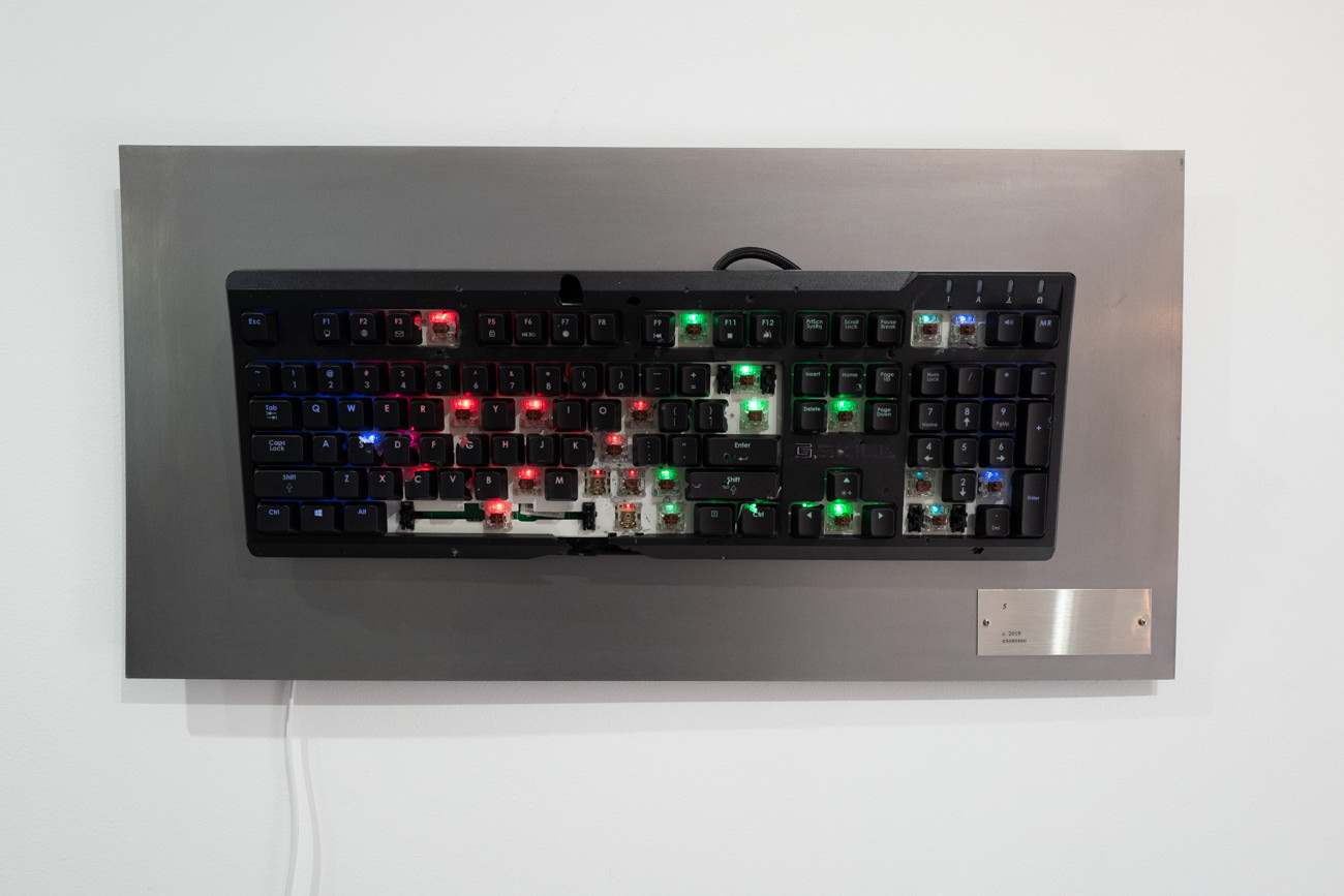 破壊されてもバックライトが生きていたキーボード。そのまま電源につながれて展示されていました