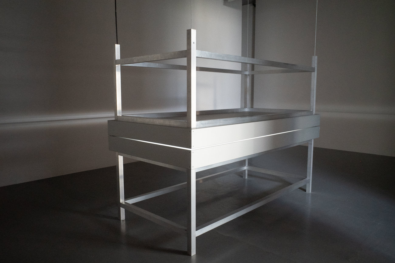 Alfredo Jaar《Lament of the images》2002年 Two aluminum tables, glass, perspex, LED lights and motor 420×244×122cm