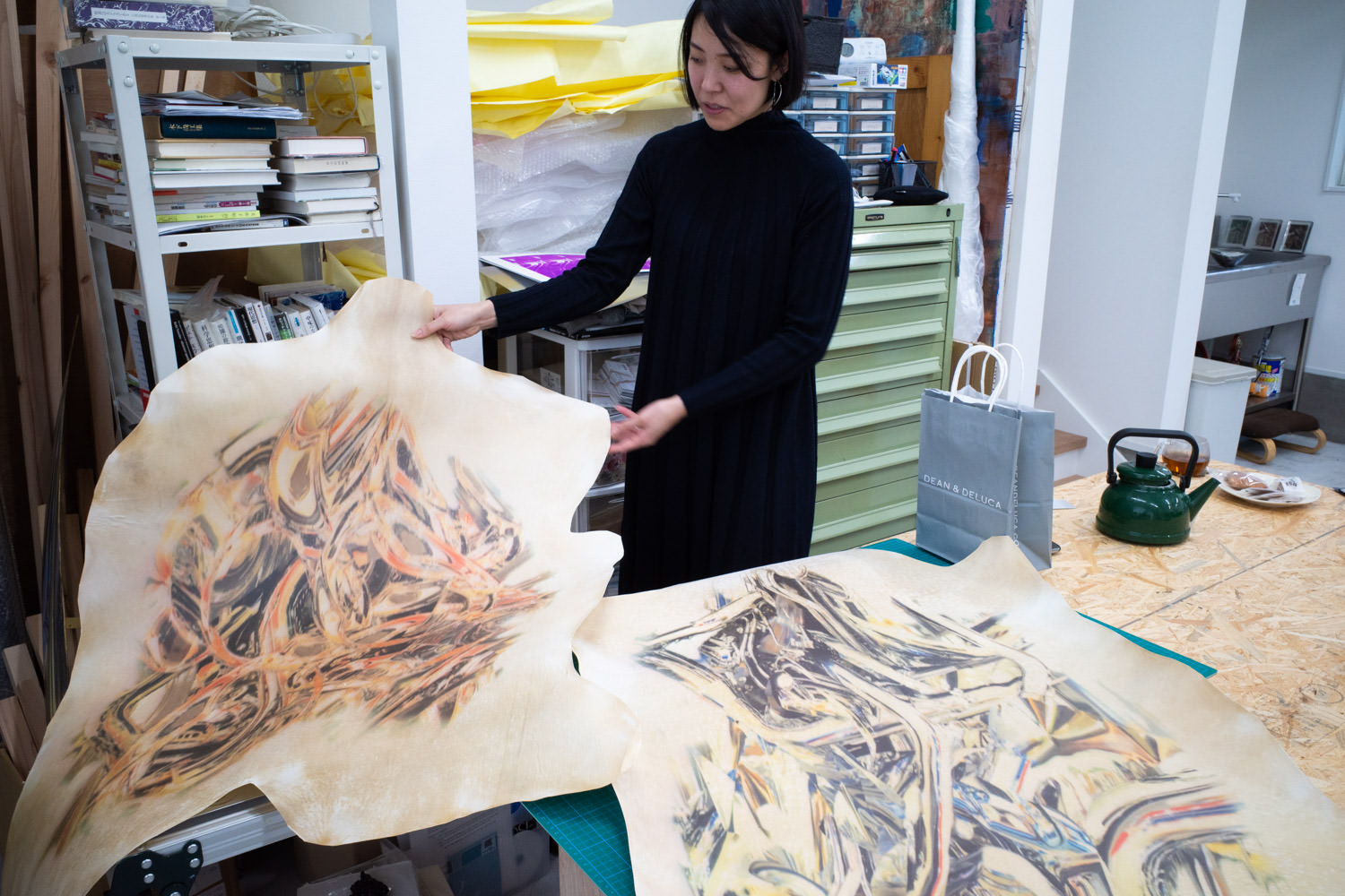 羊の皮を加工した支持体について語る牧田愛さん。※写真は制作中の作品