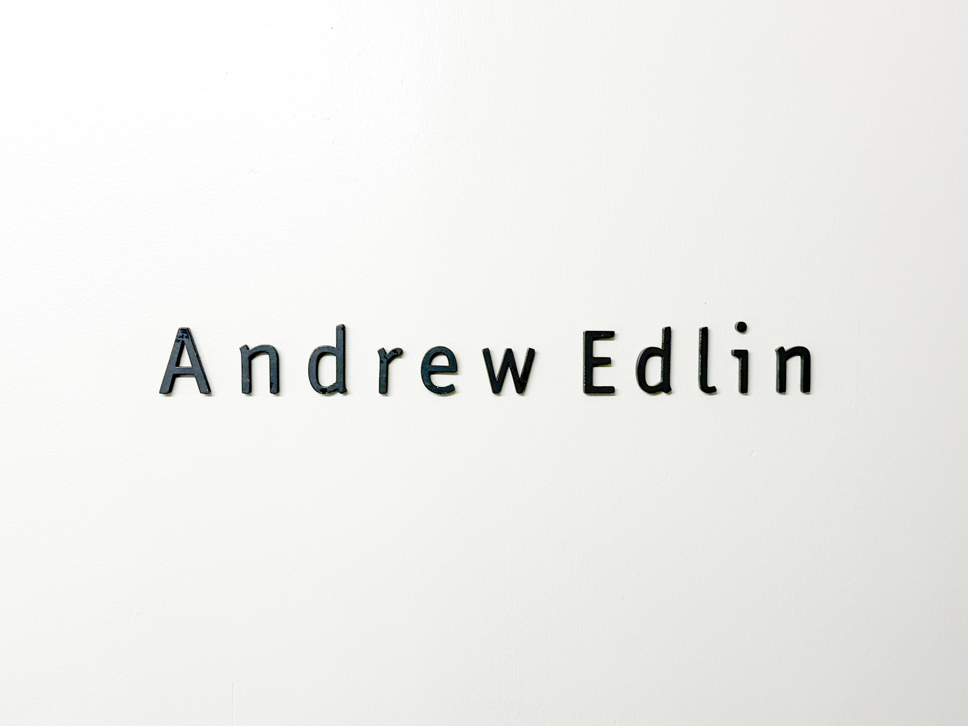 白い壁に黒い文字で「Andrew Edlin」と書かれたギャラリーの入口